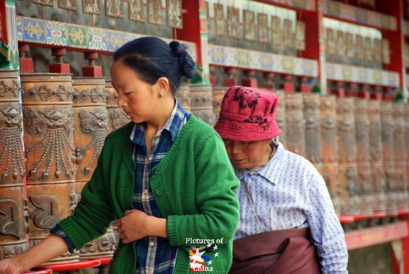 Mother and daughter turning the prayers mills